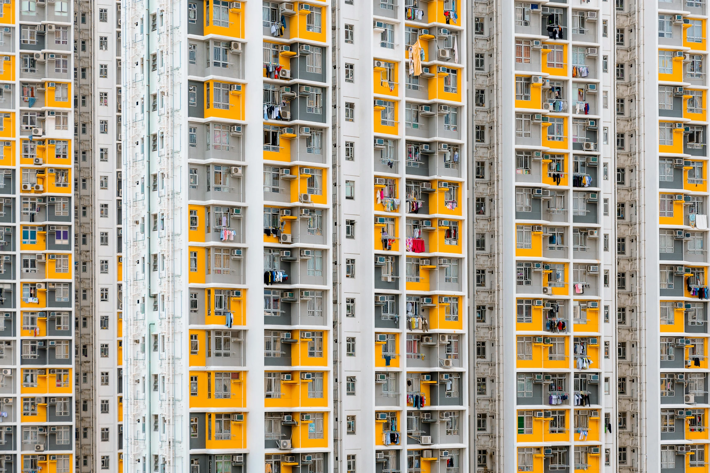 two tall buildings with balconies and yellow doors