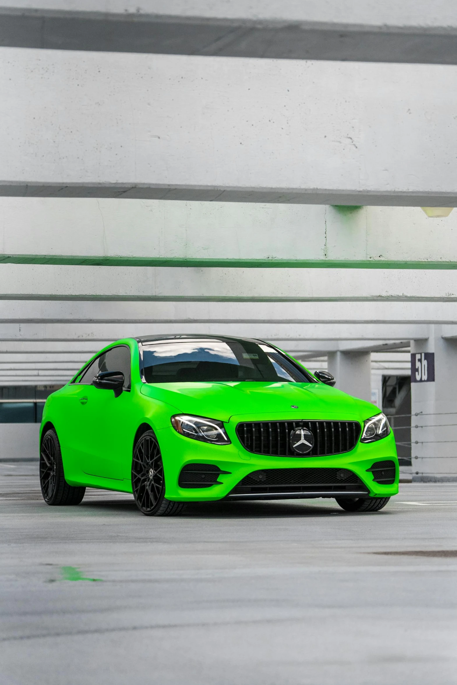 a green car parked next to a building