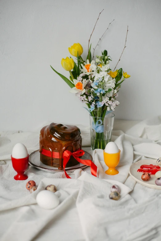 a table with an iced cake and a vase filled with flowers