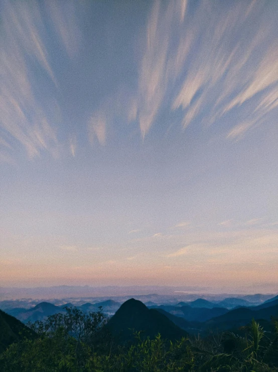 clouds in the sky above mountains under a blue sky