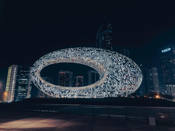 the cityscape is glowing bright with an artistic circular display of letters