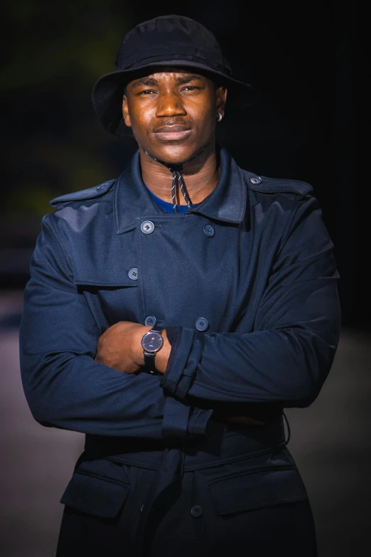 a man in a black coat and hat is smiling