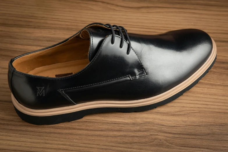 black men's dress shoes on top of a wooden table