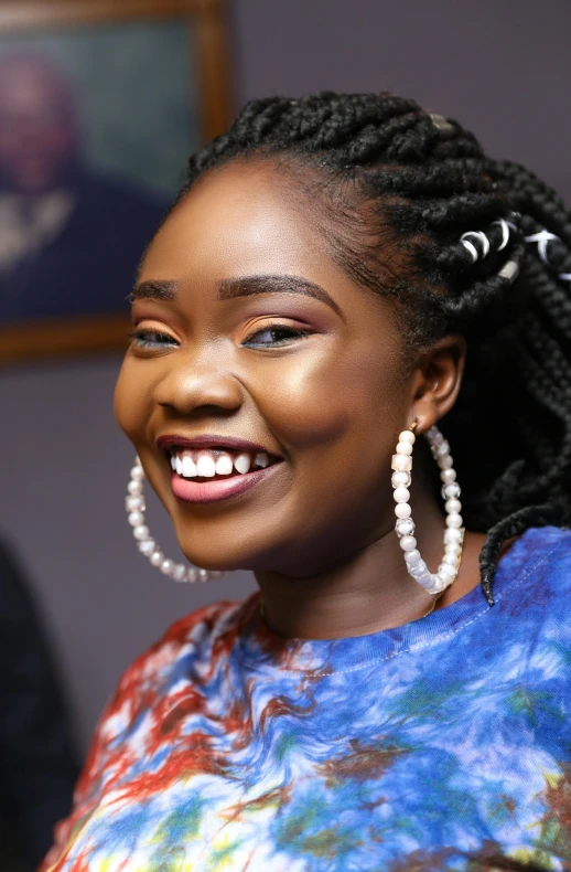 a beautiful young lady smiling while wearing large hoop earrings