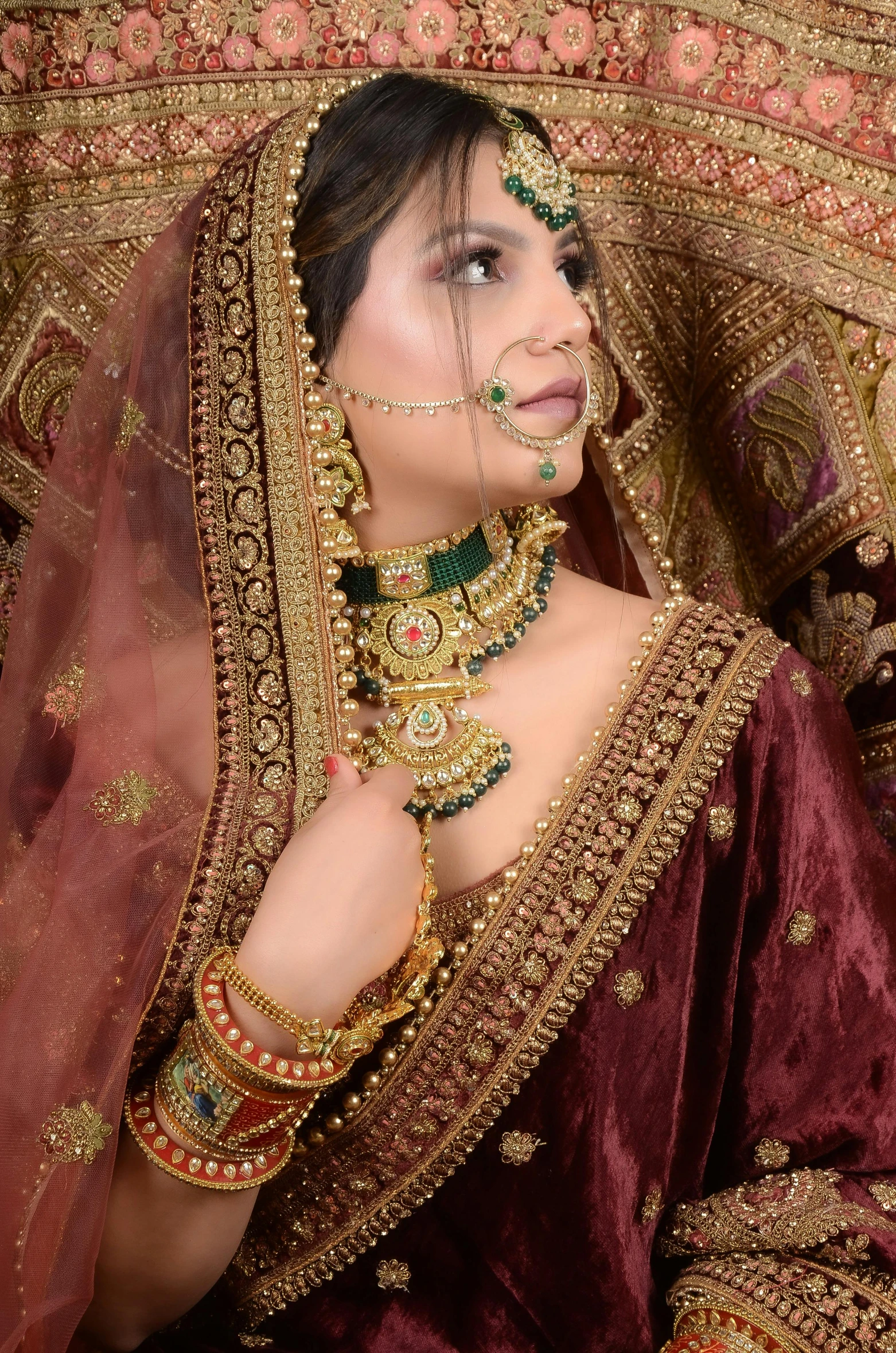 woman in indian wedding attire with golden jewelry and veil