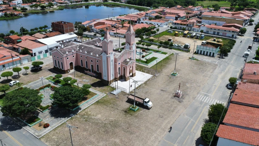 an old church next to a town and river