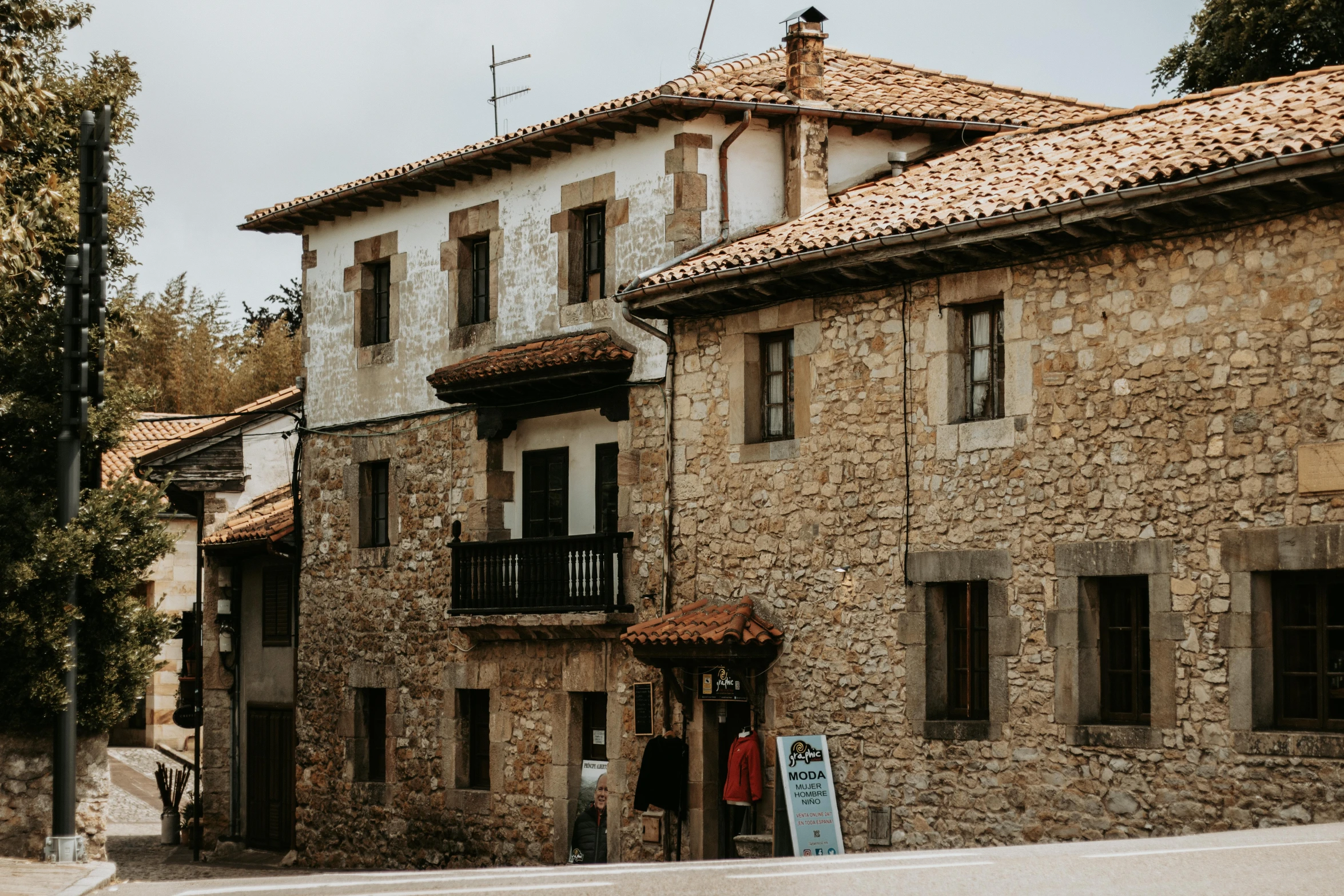 a narrow street leading to buildings with stone floors and exposed roof tops