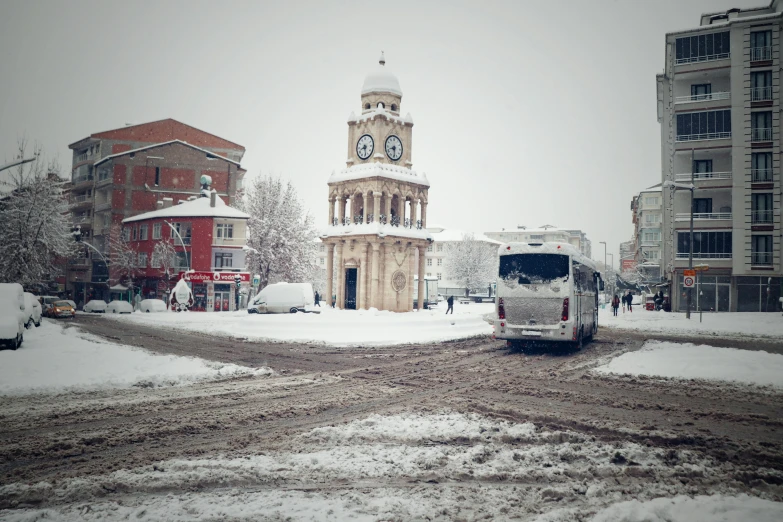 a very tall clock tower towering over a snowy city