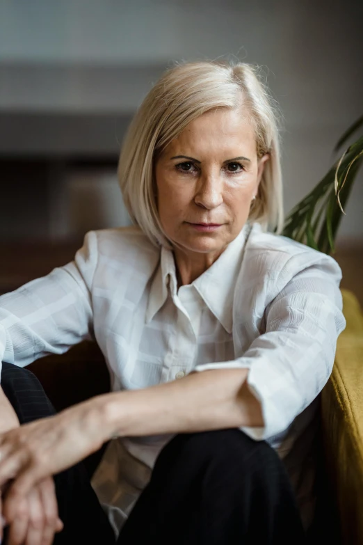 a woman with blond hair sitting on a yellow chair