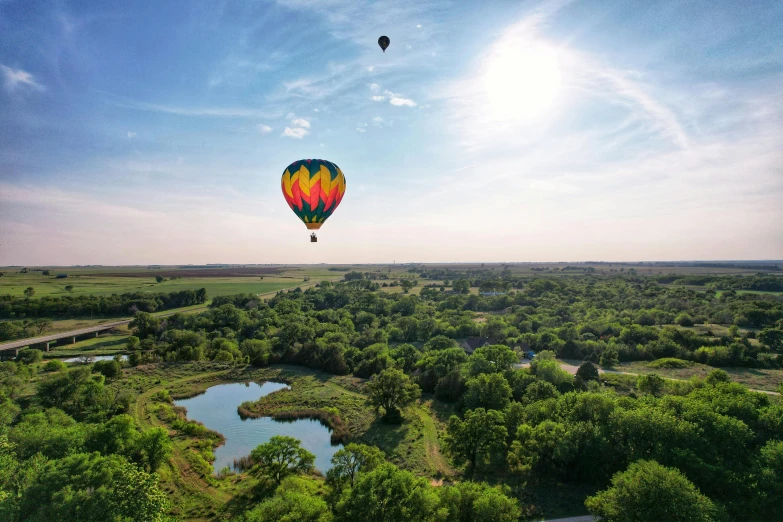  air balloons over a landscape with green trees