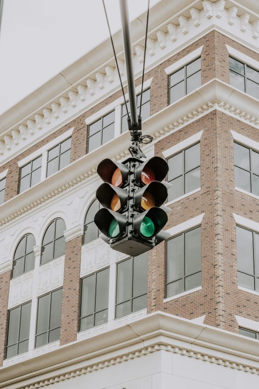 a stop light on a wire outside a tall building