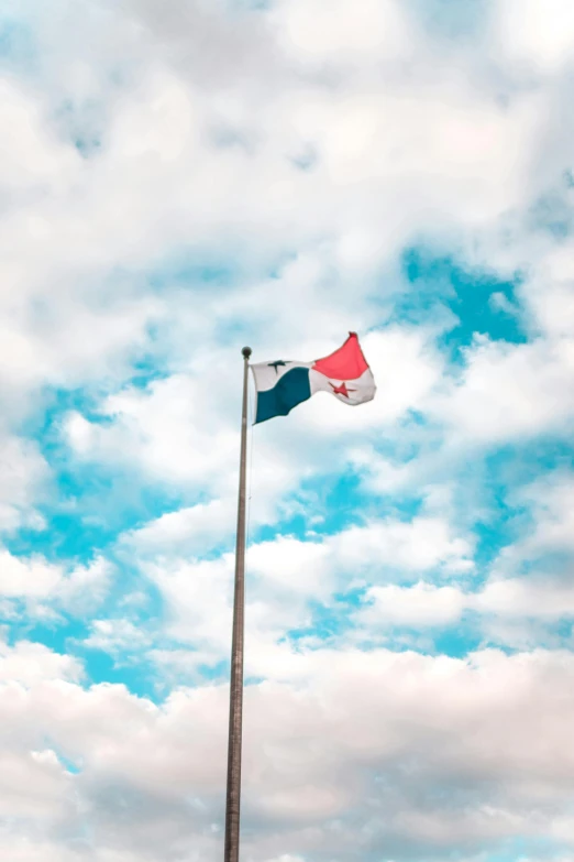 a tall flagpole with a red, white, and blue flag flying