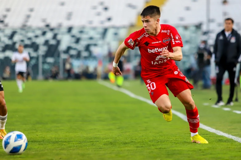 two soccer players in red and white fight for the ball