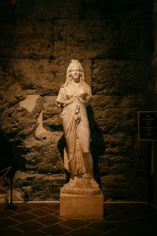 a statue in a courtyard next to a stone wall