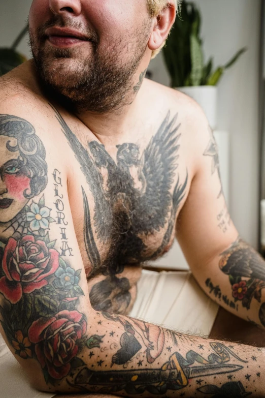 man with tattooed arms sitting in a bathtub