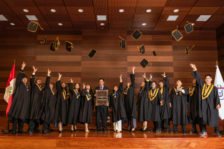 a group of graduates celeting with their diplomas