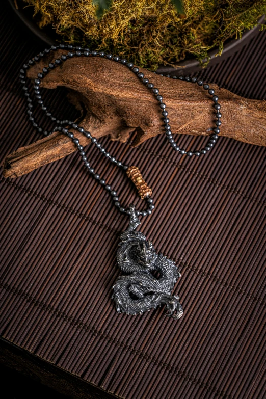 two necklaces and a small statue on a wooden table