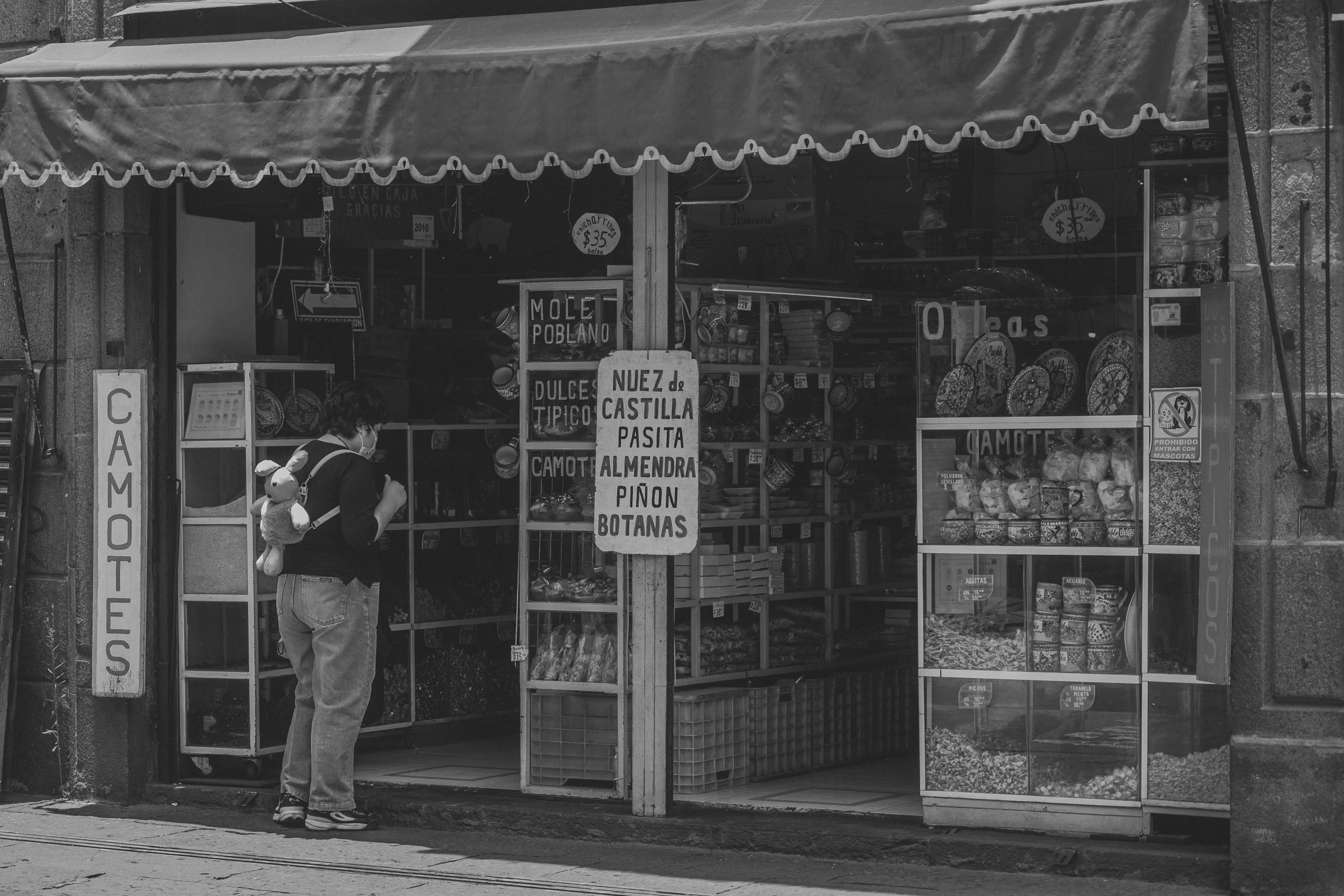 a man holding a dog standing outside of a store