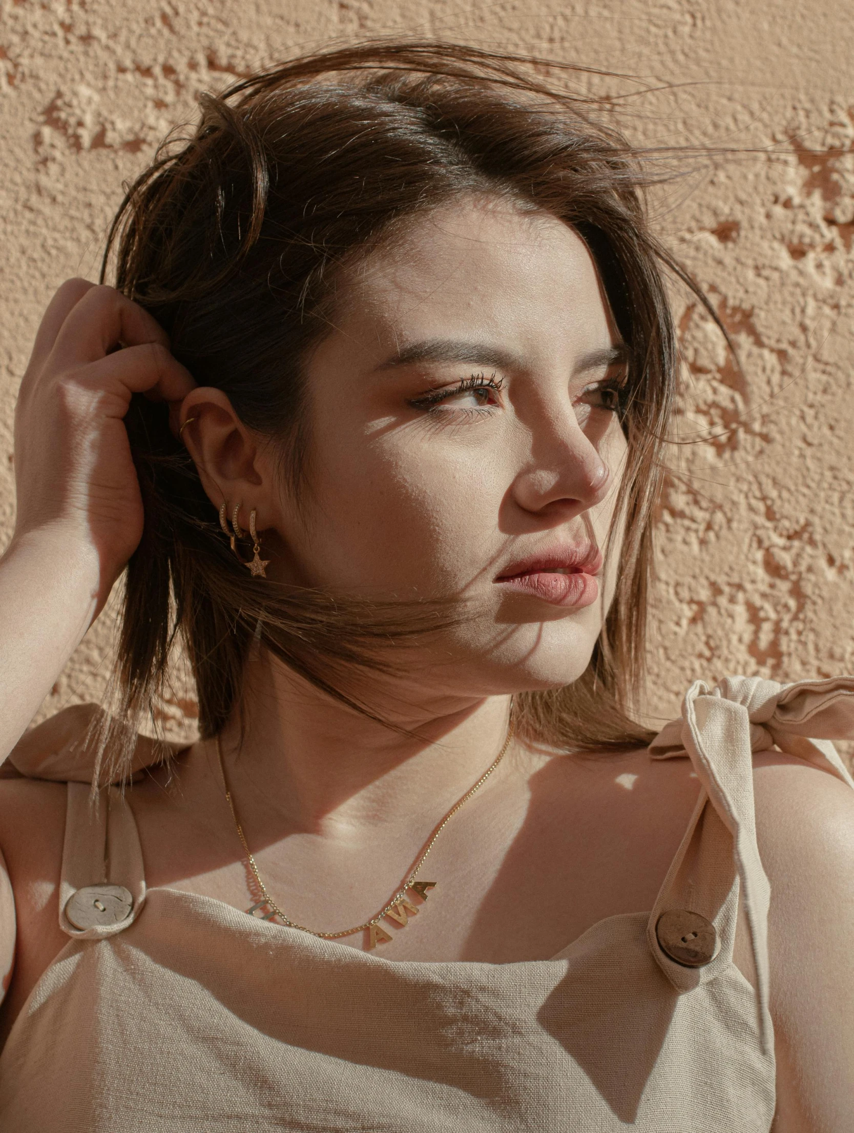 an asian woman with a necklace, hair and a sweater looks ahead to the camera