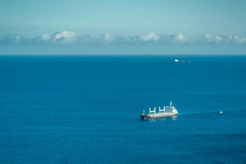 an ocean view with two ships off in the distance