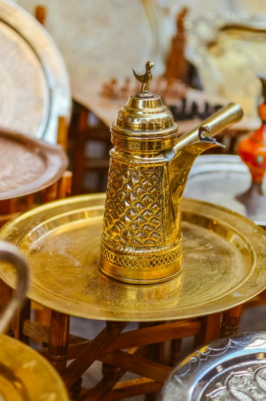 an intricately designed gold teapot sits on a tray