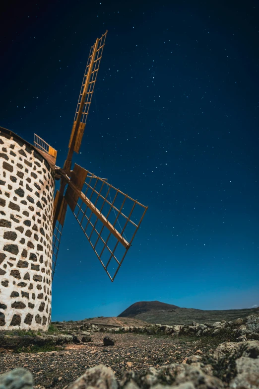 the view of a large wind mill from across the desert