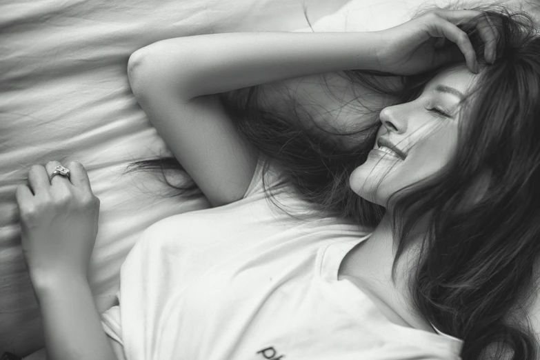 black and white pograph of girl in bed smiling