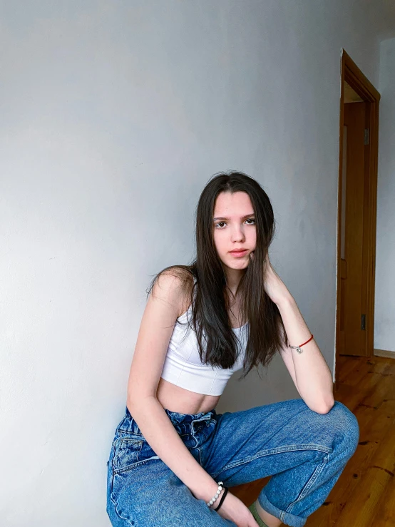 a beautiful woman sitting on top of a wooden floor