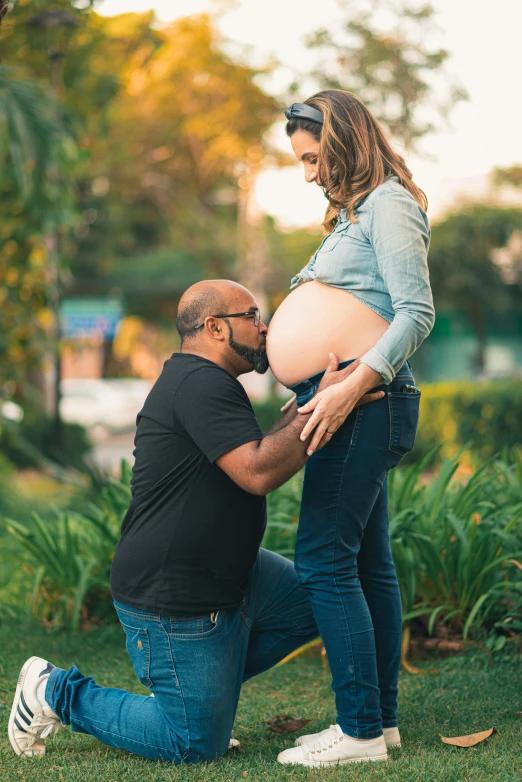 a pregnant woman is posing with a young man