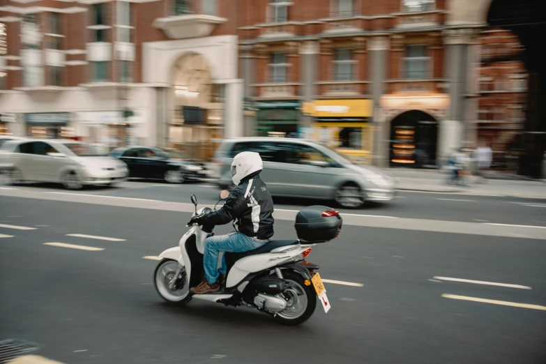 a man riding on the back of a motorcycle down a street