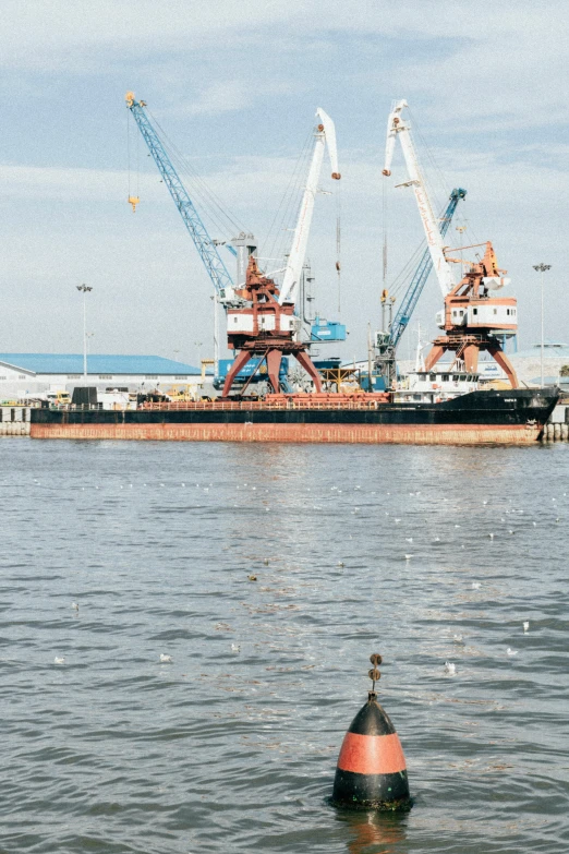 a floating buoy in the water near a barge