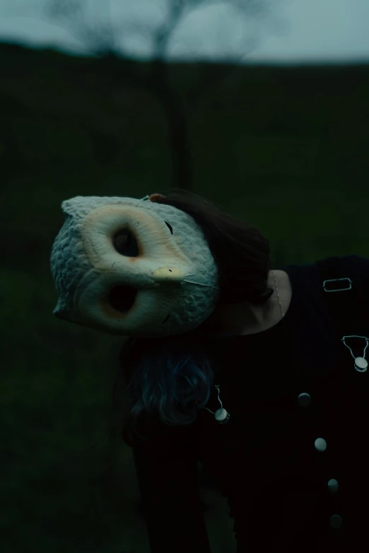 a woman in black shirt holding a donut over her face