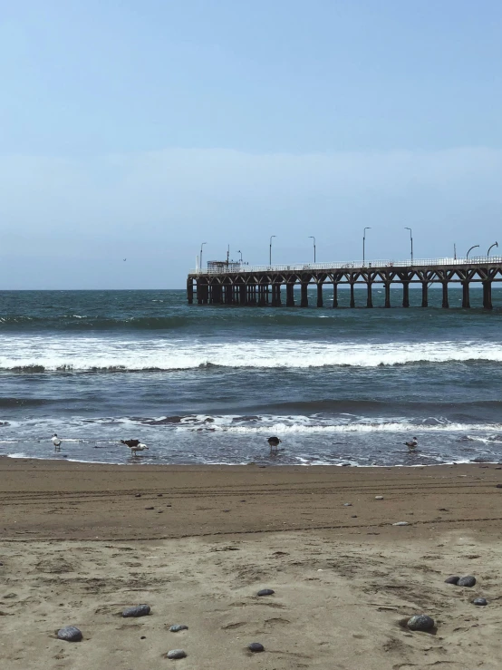 a pier is seen at the beach in front of the water