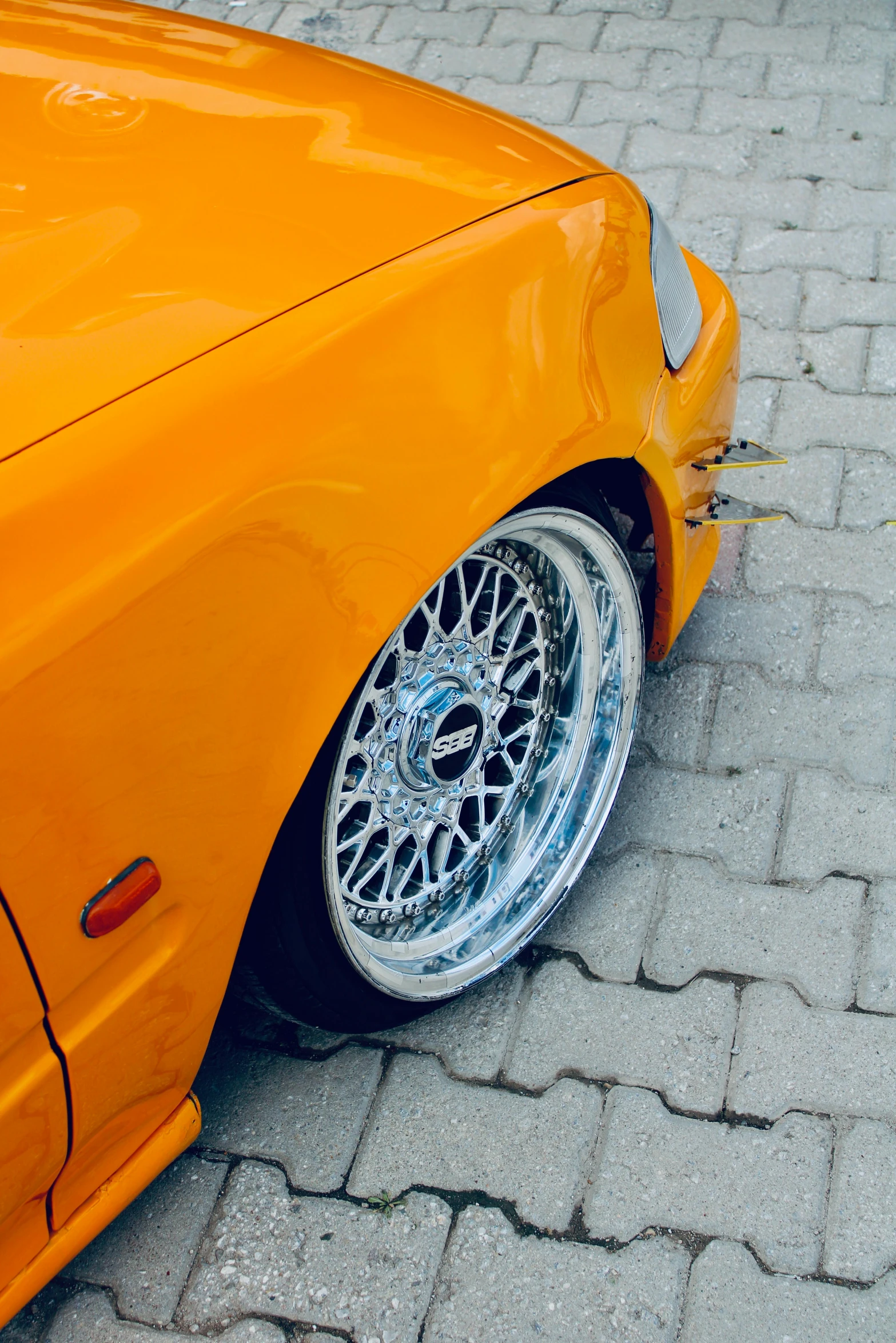 close up of orange convertible parked on the ground