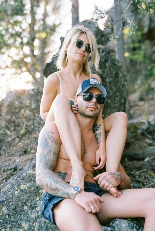 a shirtless man sitting on a woman's lap while she is on her knees