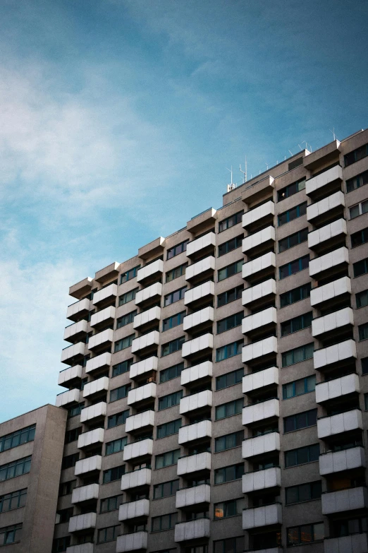 a tall building next to some windows with a sky background