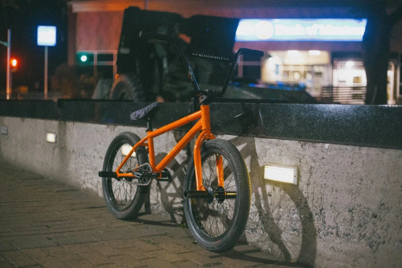 a bike sits against the wall at night