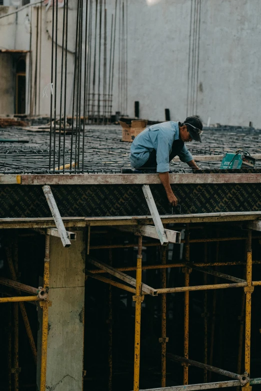 a man working on a roof trussing the form of a building