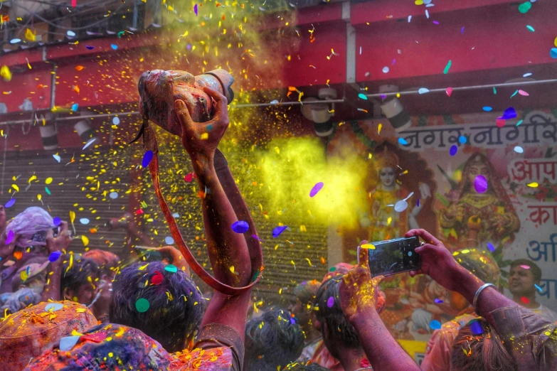 a group of people with colored powder and confetti around them