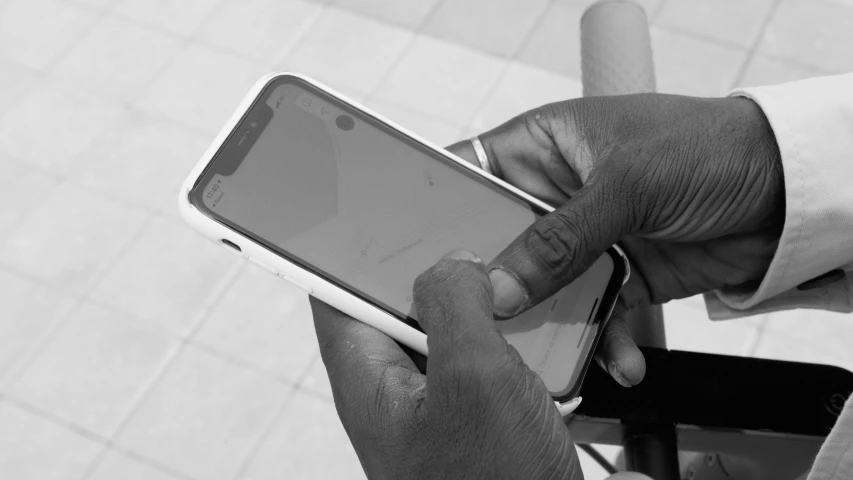 a hand that is holding a cellphone in black and white