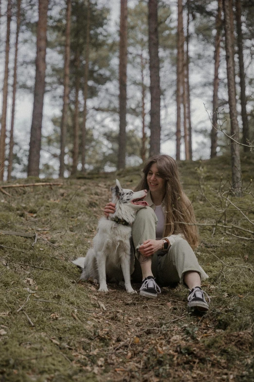 a person sitting in the grass with a dog