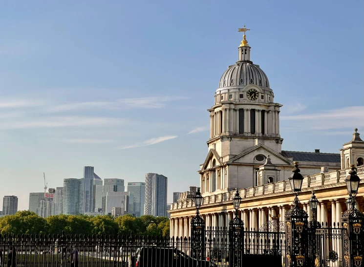 the top of the buildings looks overcast and a fence with many railings around it