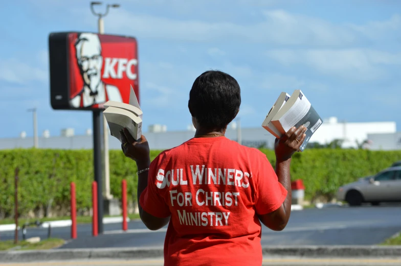 a person reading soing outside of a car dealership