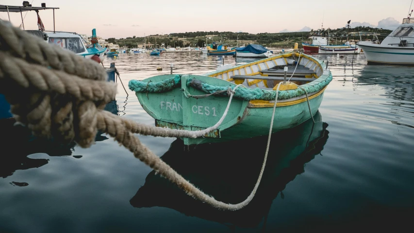 a boat docked on top of water with rope around it