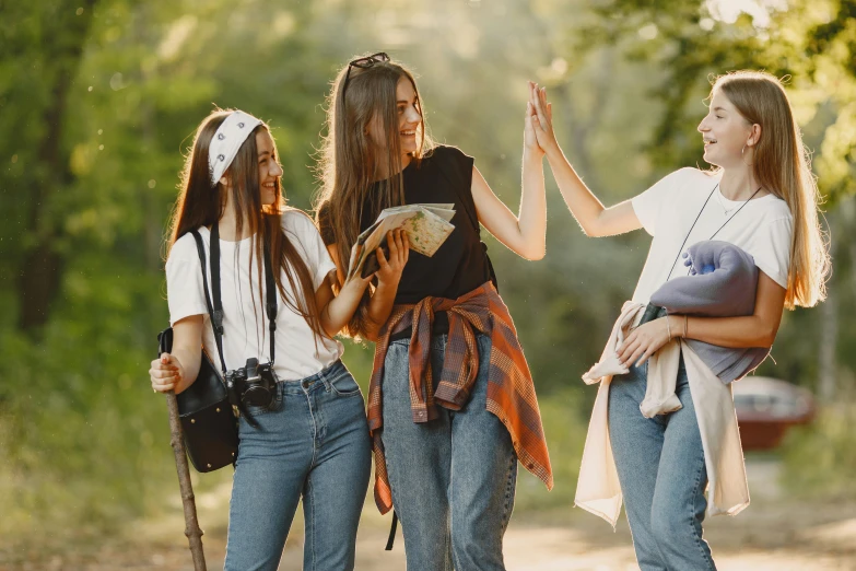 three girls are standing together in the woods