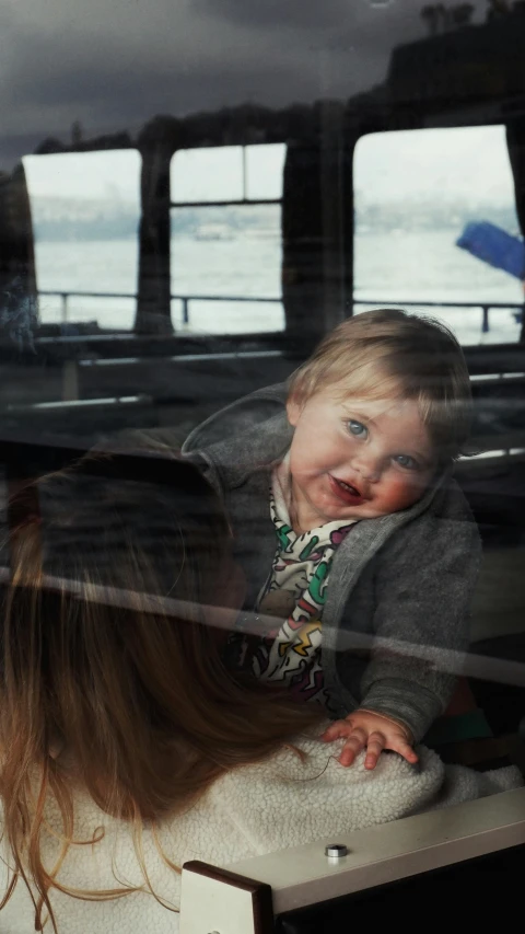 a child sitting on a luggage compartment in the back of a vehicle