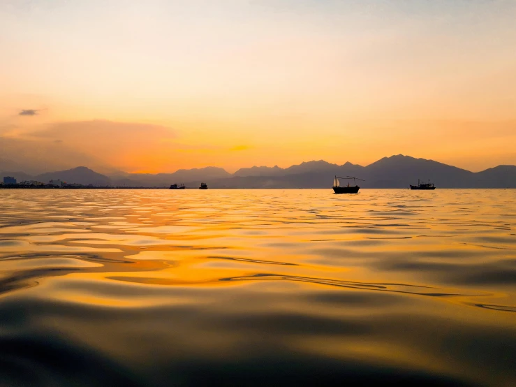 an orange and yellow sunset over the water