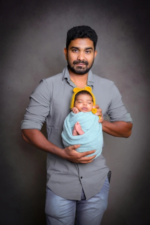 a man is holding a small child in a sling