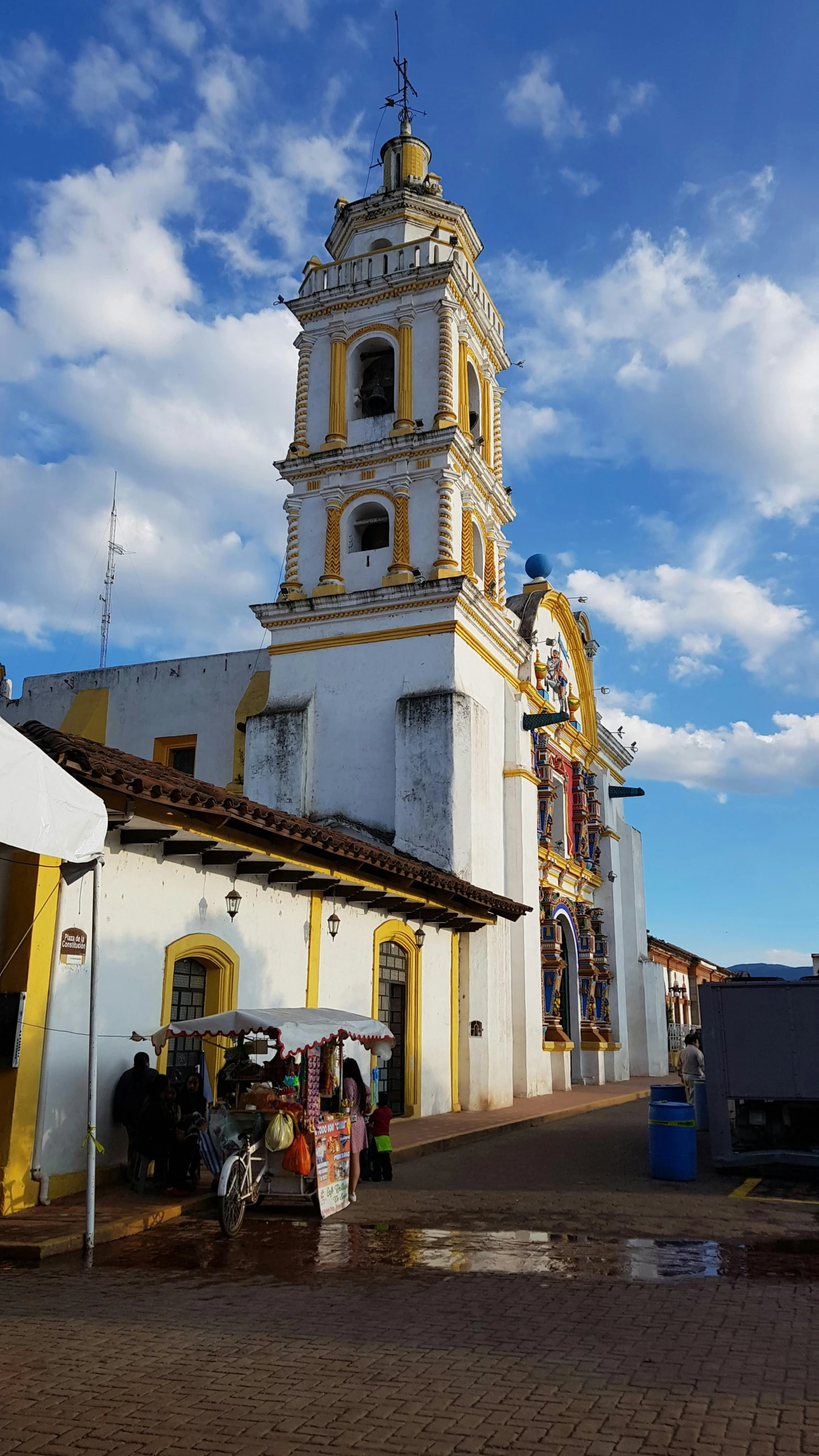 a building with two floors is white and has yellow trim