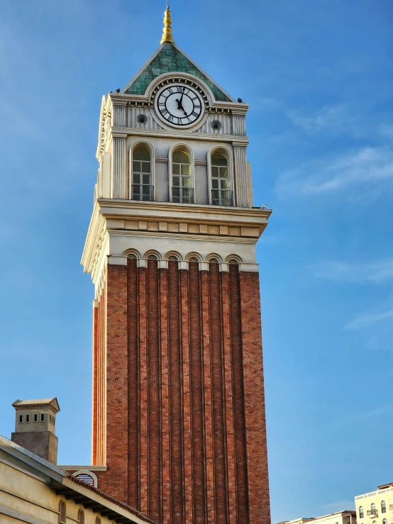 a very tall brick clock tower with a clock on it's side